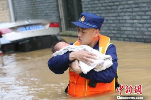 6月10日，江西省吉安縣梅塘鄉(xiāng)渡口村，消防員蹚著齊腰深的洪水，小心翼翼地將嬰兒轉(zhuǎn)移到安全地帶?！」逶?攝